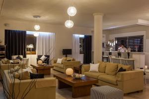 a living room with couches and chairs and a table at Skopelos Holidays Hotel & Spa in Skopelos Town