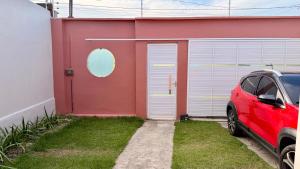 a red car parked in front of a red building at Casa completa em Bragança in Bragança
