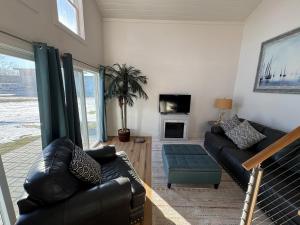 a living room with a couch and a tv at Cozy cabin by the lake in Spring Lake
