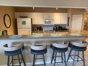 a kitchen with a counter with four bar stools at Lake Ozarks Get Away Topsider in Lake Ozark