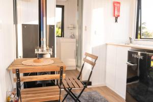 a small kitchen with a wooden table and a chair at The Nest at Arahura Escape by Tiny Away in Kaihinu