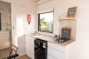 a small kitchen with a sink and a stove at The Nest at Arahura Escape by Tiny Away in Kaihinu +30 photos