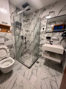 a marble bathroom with a toilet and a shower at N3XT-LEVEL Pool in Praia