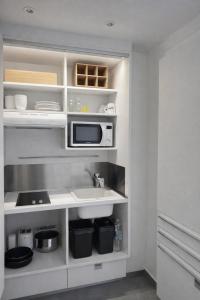 a kitchen with a sink and a microwave at La Casaboubou in Saint-François