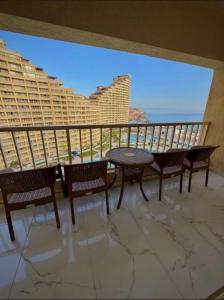 a balcony with a table and chairs and a view of the ocean at Porto El Sokhna in Ain Sokhna