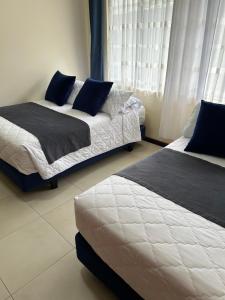 a bedroom with two beds and a window at Boutique Exclusive Stay in Baños