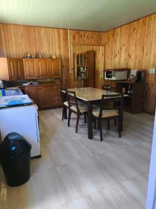 a kitchen with a table and chairs and a refrigerator at Casa de campo da Prof Fabi in Montenegro