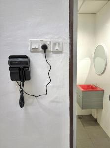 a phone is plugged into a wall in a bathroom at M Guest House2 in Muar