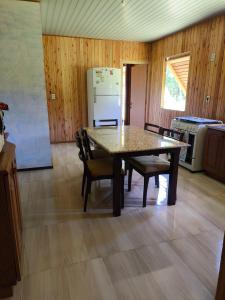 a kitchen with a table and chairs and a refrigerator at Casa de campo da Prof Fabi in Montenegro +6 photos