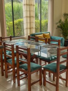 a living room with a glass table and chairs at Boutique Exclusive Stay in Baños