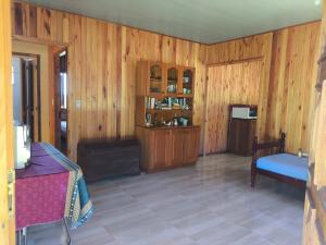 a living room with wood paneling and a couch and a chair at Casa de campo da Prof Fabi in Montenegro