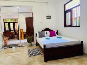 a bedroom with a bed with two blue stars on it at Arumathi Villa in Bentota