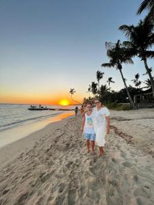 a woman and a child standing on a beach at Apartamento Juan Dolio in Juan Dolio