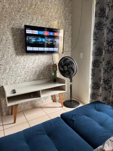 a living room with a couch and a tv on a wall at Encanto Parangaba in Fortaleza