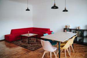 a living room with a red couch and a table at Casa Magenta - Alojamento Local in Trofa