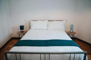 a bed in a room with two side tables at Casa Magenta - Alojamento Local in Trofa