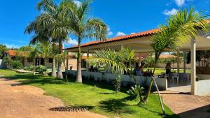 a house with palm trees in front of it at Pousada Elizium in Montes Claros
