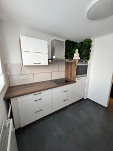 a kitchen with white cabinets and a counter top at Red Silence I Design Suite im Koblenz in Bendorf