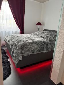 a bedroom with a bed with a red light on it at Red Silence I Design Suite im Koblenz in Bendorf