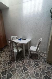 a table and two chairs and a white table and chairs at Hospedaje Donde Jaime-Choachí in Choachí