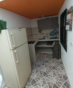 a small kitchen with a refrigerator and a sink at Hospedaje Donde Jaime-Choachí in Choachí