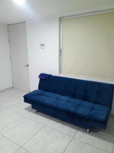 a blue couch in a room with a large window at Dónde Habita in Circasia