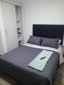 a bed with a blue blanket on top of it at Dónde Habita in Circasia