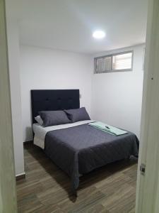 a bedroom with a bed with a black headboard at Dónde Habita in Circasia