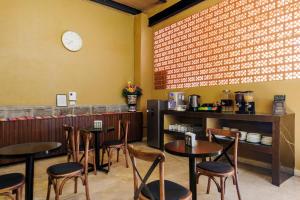 a restaurant with tables and chairs and a clock on the wall at Colmena Hotel CDMX Centro in Mexico City