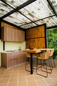 a patio with a table and chairs and a kitchen at Villajesu Villeta in Villeta