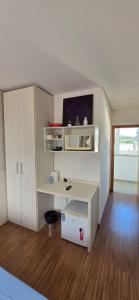 a room with a white desk and a tv at Flats Paris in Lagoa Santa