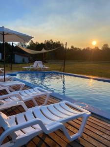 a group of lounge chairs sitting next to a swimming pool at Cabañas Campestres Villarrica in Villarrica