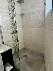 a shower with a glass door in a bathroom at La Casaboubou in Saint-François +15 photos