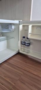 an empty refrigerator with its door open on a wooden floor at Flats Paris in Lagoa Santa