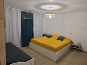 a bedroom with a yellow bed and a window at Premium Villa, Maison du Manguier in Les Anses-dʼArlets