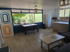 a living room with a table and a kitchen at Premium Villa, Maison du Manguier in Les Anses-dʼArlets
