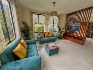 a living room with two blue couches and a tv at Boutique Exclusive Stay in Baños