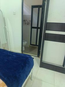 a bedroom with a blue bed and a mirror at D'sawah Guest House in Kota Bharu +30 photos