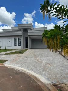 a white building with a driveway in front of it at Mini Palacete in Ribeirão Preto
