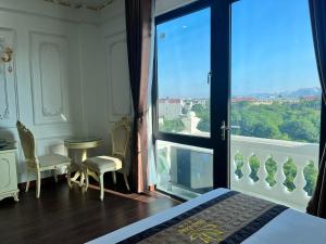 a bedroom with a large glass door with a view at The Téa Opera Hotel - Hoa Đông Aureum in Châu Cầu