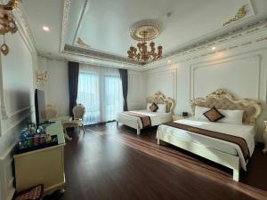 a large bedroom with two beds and a chandelier at The Téa Opera Hotel - Hoa Đông Aureum in Châu Cầu