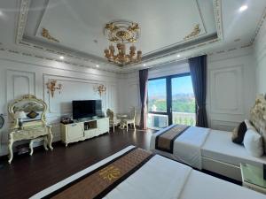 a bedroom with a bed and a television and a chandelier at The Téa Opera Hotel - Hoa Đông Aureum in Châu Cầu