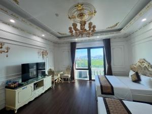 a bedroom with a bed and a television and a chandelier at The Téa Opera Hotel - Hoa Đông Aureum in Châu Cầu +33 photos