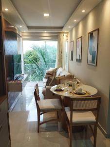 a living room with a table and a couch at 05 minutos da praia - Casa Superior céu azul Buzios in Búzios +19 photos