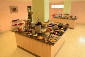 a buffet in a kitchen with food on a counter at Hotel Capital in Cuiabá