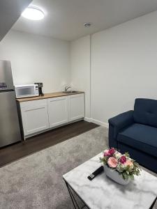a living room with a blue couch and a table at Lizzy cozy Basement suite in Airdrie
