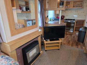 a living room with a fireplace and a television at Beachside Ingoldmells, 2 bedroom, Wifi in Ingoldmells +10 photos