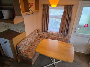 a small kitchen with a table and a couch at Beachside Ingoldmells, 2 bedroom, Wifi in Ingoldmells
