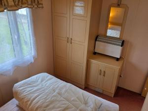 a bedroom with a bed and a tv in it at Beachside Ingoldmells, 2 bedroom, Wifi in Ingoldmells