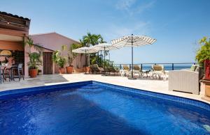 a swimming pool with a view of the ocean at Quinta Maria Cortez Beach Hotel in Puerto Vallarta